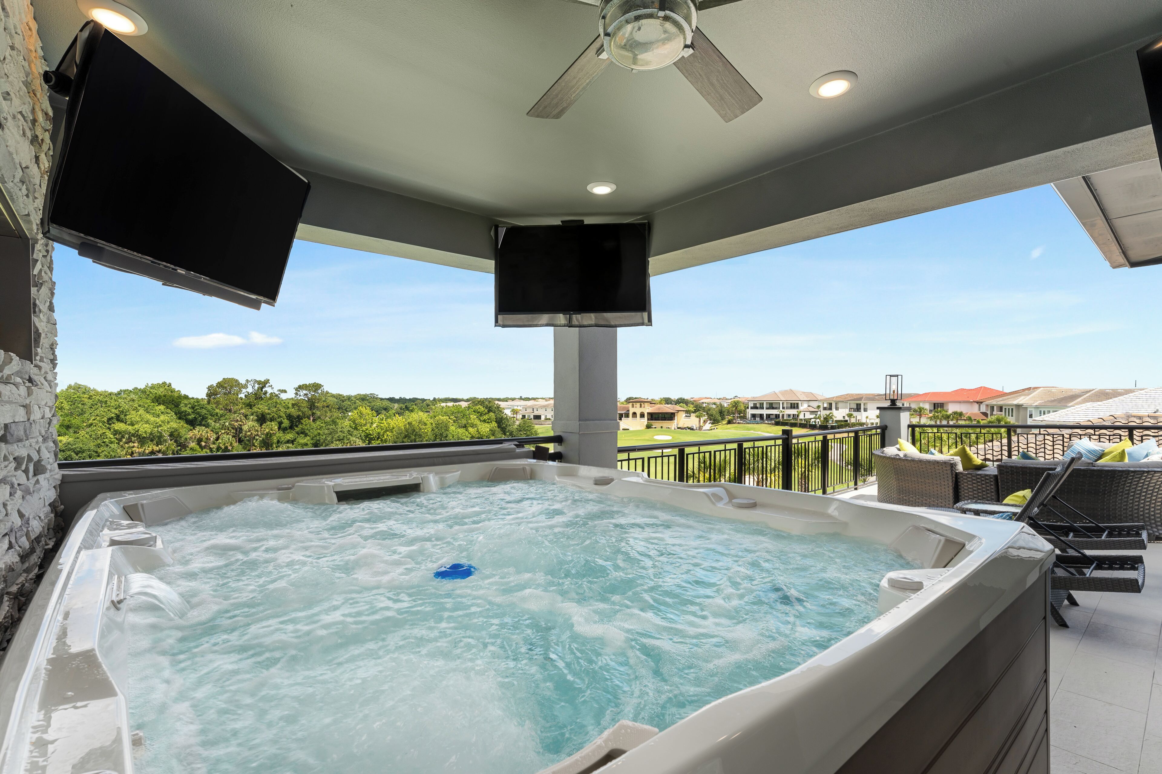 Banheira de hidromassagem com vista para um campo de golfe e casas.
