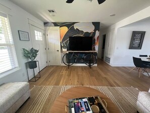 A spacious living area with a sofa, a coffee table, and a bicycle in the background.