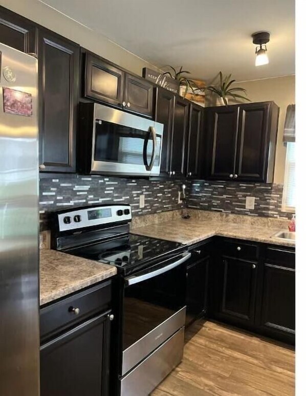 Enjoy cooking in this well-equipped kitchen with a refrigerator, microwave, oven, and dishwasher.