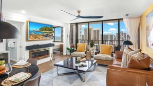 A modern living room with a fireplace, large windows, and a city view.