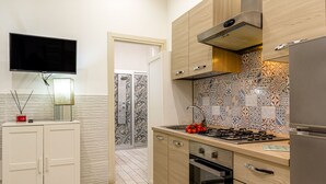 Une cuisine moderne avec des meubles en bois, une cuisinière encastrée et un réfrigérateur en acier inoxydable.