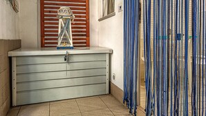 Ein Badezimmer mit Holztür, einer kleinen Ablage mit einem dekorativen Gegenstand und einem gestreiften Vorhang.
