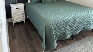A bedroom with a bed, two nightstands, a lamp on each, and a forest mural on the wall. - Cozy family retreat with great parking for multiple boats and vehicles! (Guntersville)