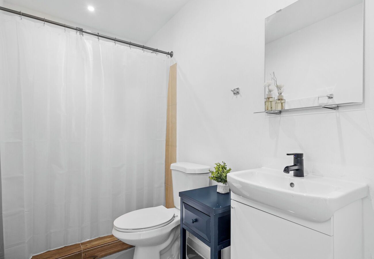 Un baño moderno con inodoro, lavabo y cortina de ducha.
