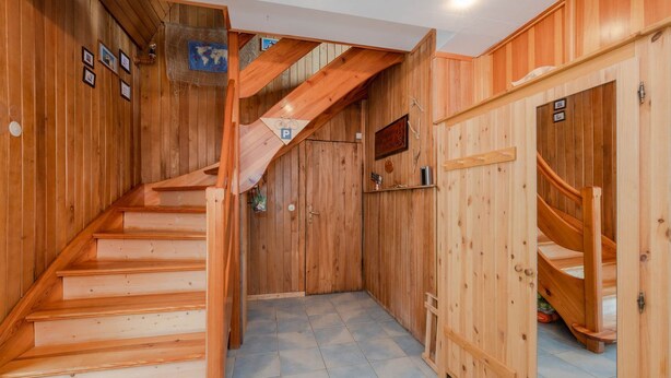 Un intérieur en bois avec un escalier menant à une mezzanine.