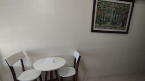 Un comedor con una mesa redonda y cuatro sillas. Hay un cuadro enmarcado en la pared sobre la mesa.