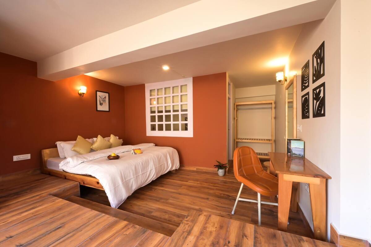 A bedroom with a bed, a desk, and a chair.