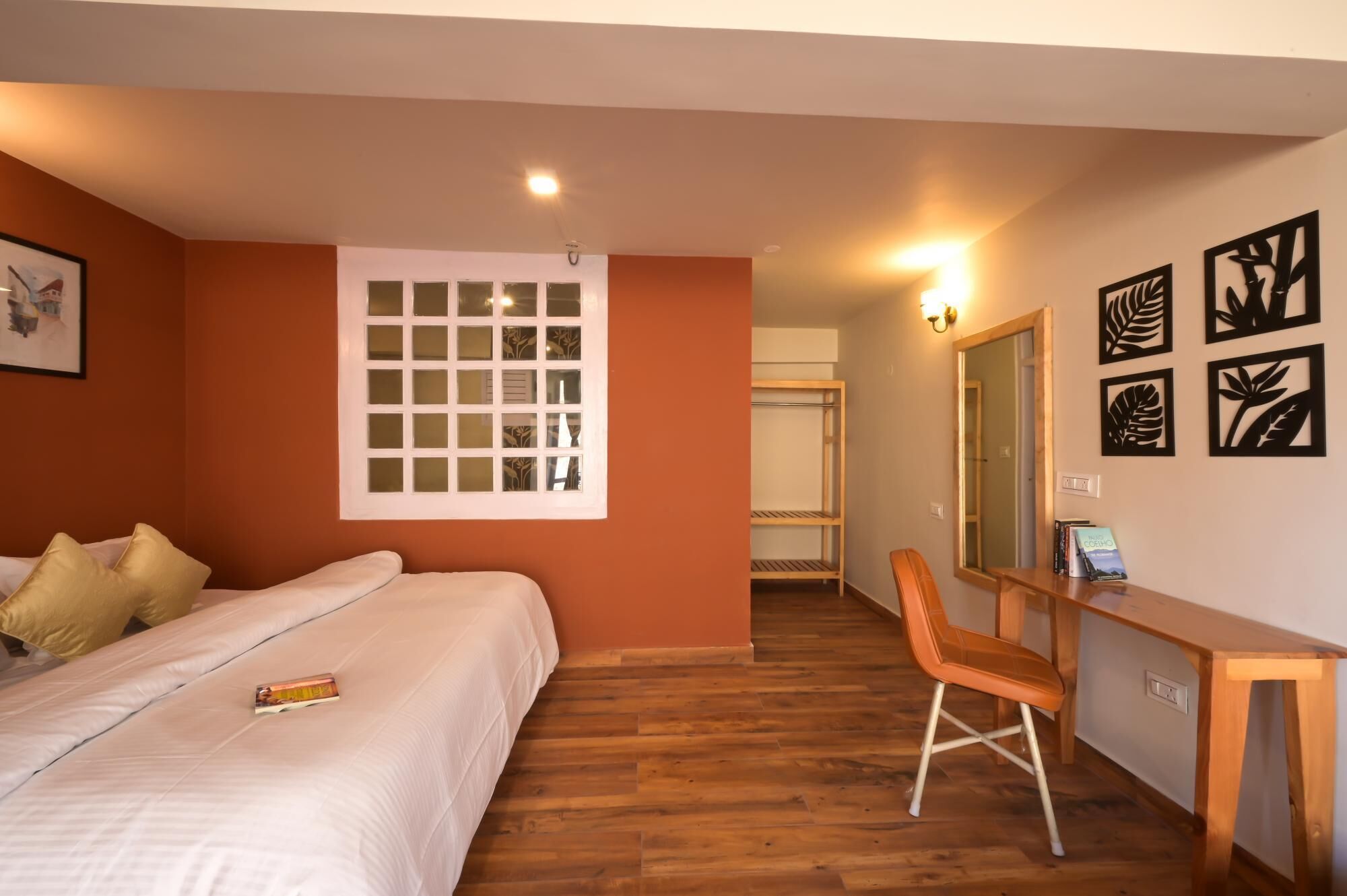 Una habitación de hotel con cama, escritorio, silla y espejo.