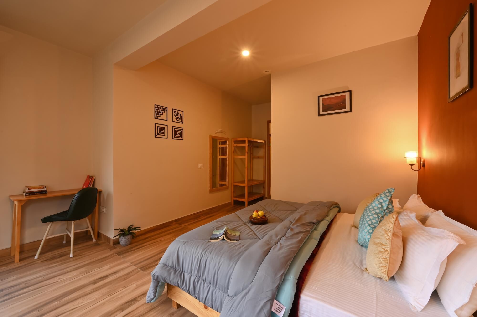 Quarto com cama, mesa de cabeceira, cadeira, escrivaninha e guarda-roupa.