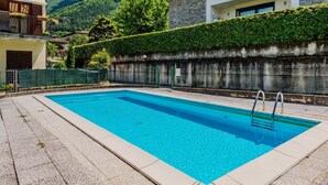 Une piscine rectangulaire avec un escalier, entourée d’une terrasse en pierre.