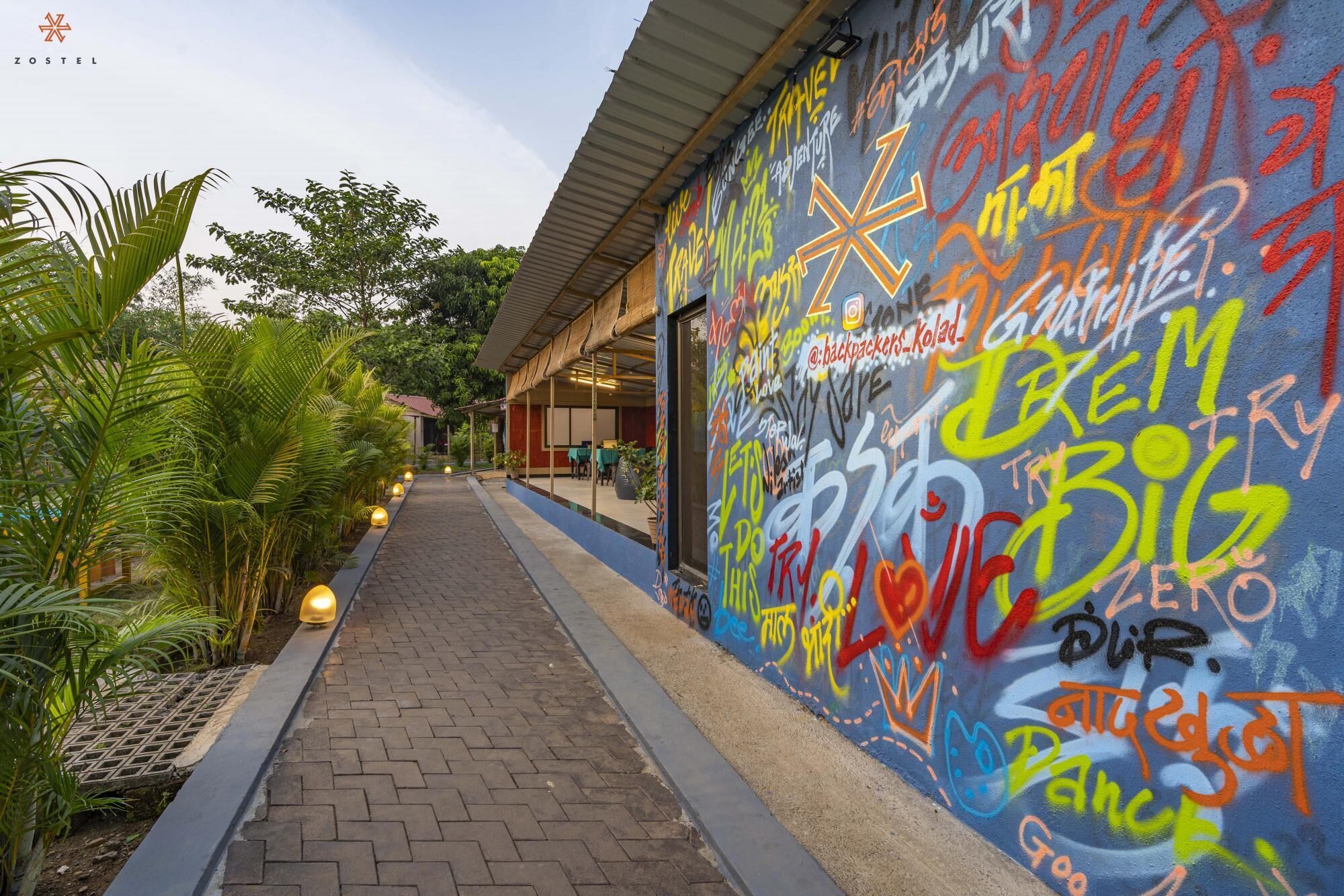 A pathway leading to a building with a colorful graffiti-covered wall.