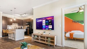 A modern apartment with a kitchen, dining area, and a bedroom. - Modish Keen King Bed w/ Pool (Houston)
