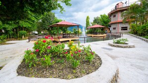 A courtyard with a fountain, outdoor seating, and a flower bed. - Zostel Pokhara (Pokhara)