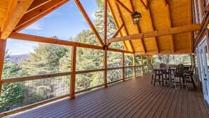 A wooden deck with a view of a forested landscape.