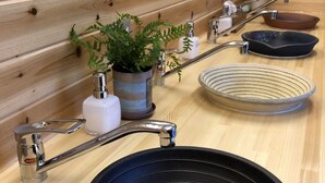 A wooden interior with a black basin sink, a small potted plant, and a metal faucet.