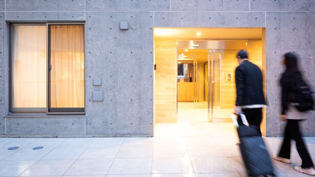 A modern building with a concrete facade, large windows, and a well-lit entrance. - MINI HOUSE Tokyo South (Tokyo)