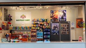 A candy store named 'Fazzy Peazy Candy' with shelves of colorful candies and a 'Wednesday' sign. - Luxury, centrally located loft Downtown w/skybridge access to Convention Center (Indianapolis)