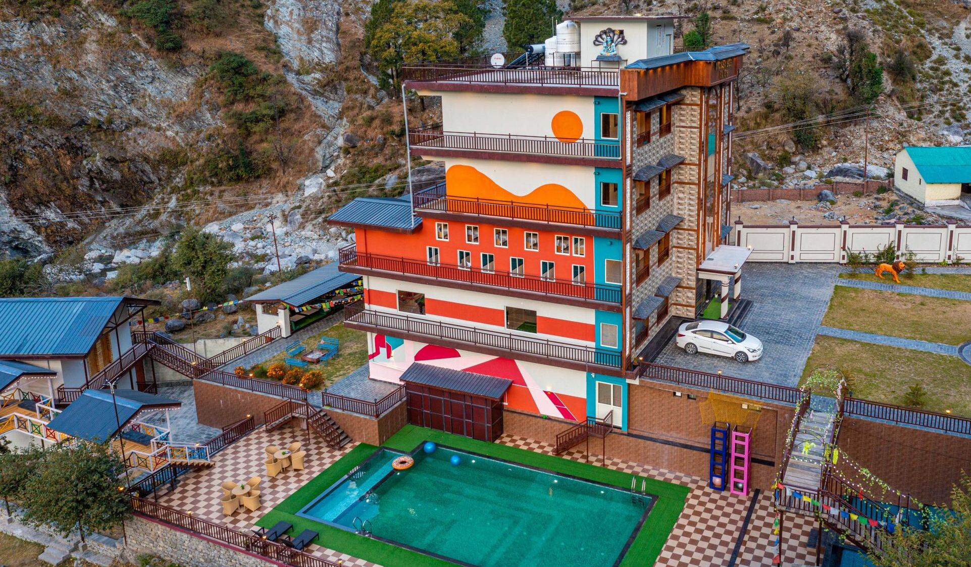 Un hôtel à plusieurs étages doté d’une piscine, d’un espace extérieur aménagé et offrant une vue sur le paysage environnant.