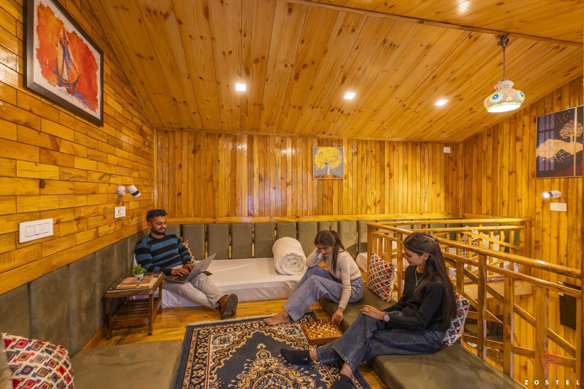 A wooden room with a bed, a small table, and a chessboard.