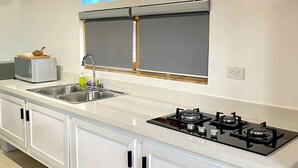 A modern kitchen with a white countertop, stainless steel sink, and a gas stove. - C-402 Loft apt in Punta Cana, los Corales Beach/pool (Punta Cana)