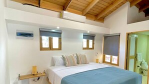 A bedroom with a wooden bed frame, a blue bedspread, and two bedside tables with lamps. - C-402 Loft apt in Punta Cana, los Corales Beach/pool (Punta Cana)