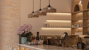 A modern kitchen with a central island, bar stools, and pendant lighting. - Jodi Dalat Hotel (Lam Vien - Da Lat)