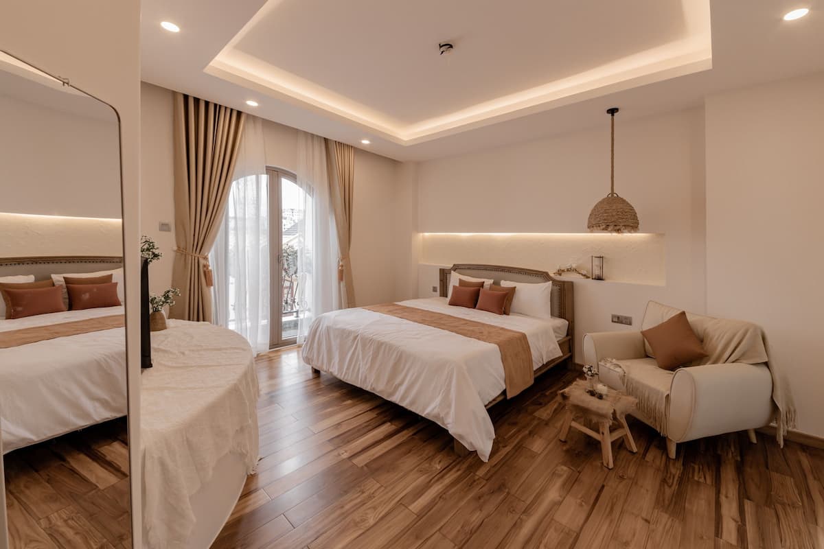 Ein Hotelzimmer mit zwei Betten, einem Sofa und einem kleinen Tisch.