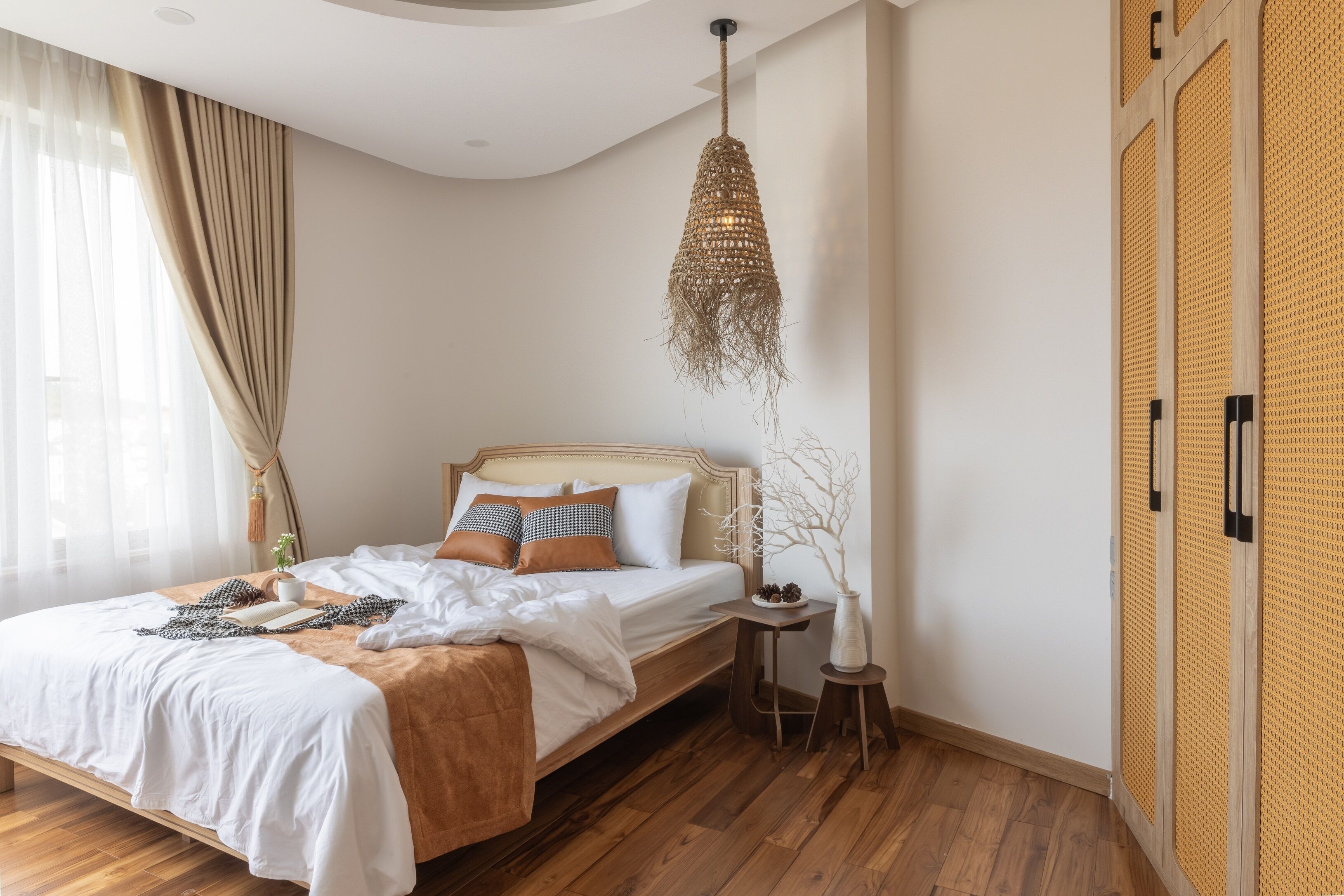A bedroom with a wooden bed, a hanging light fixture, a small bedside table, and a wardrobe with a textured door.