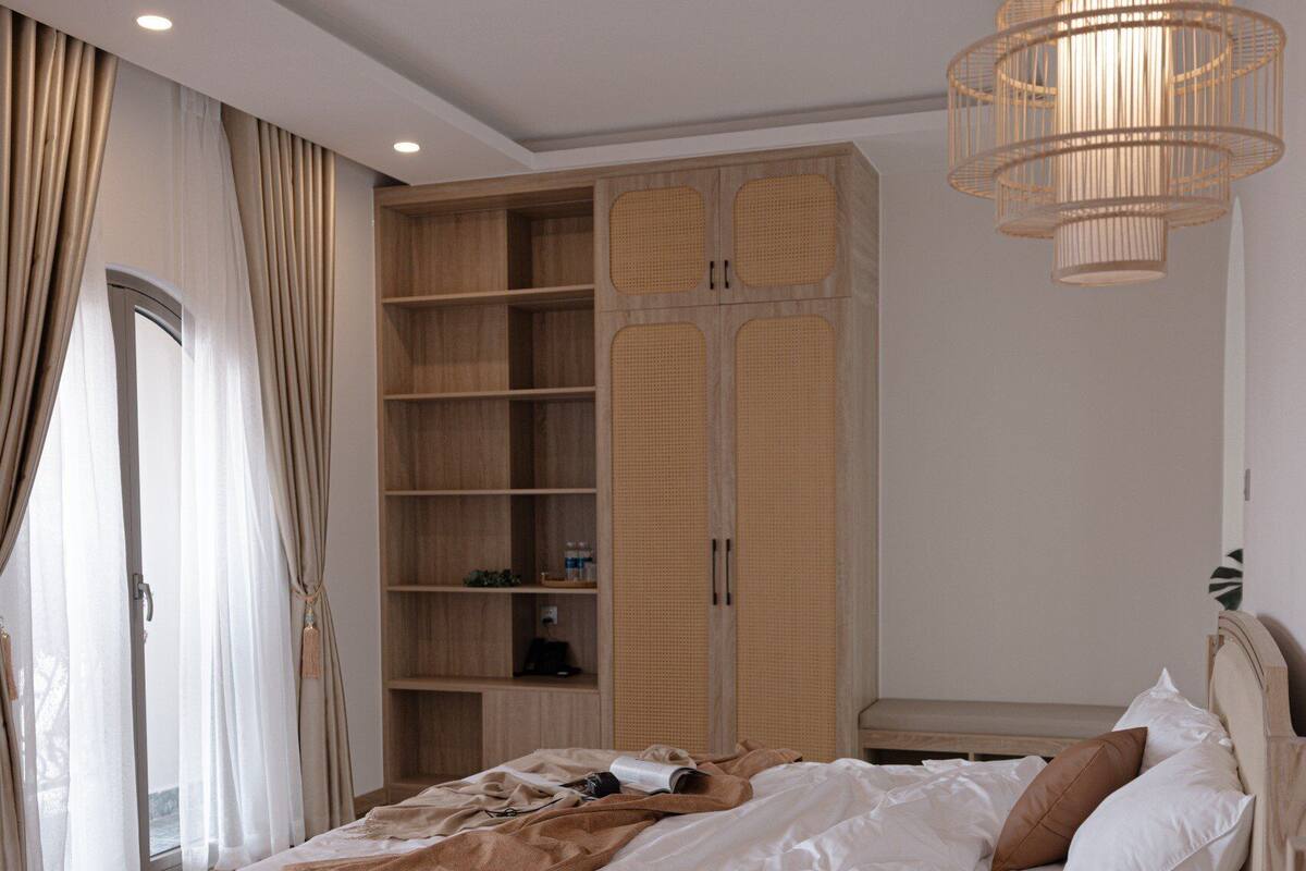 Ein Schlafzimmer mit zwei Betten, einem großen Kleiderschrank und einer Hängeleuchte.