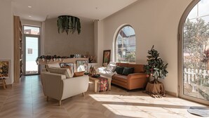 A spacious living room with a large window, a fireplace, and a Christmas tree. - Jodi Dalat Hotel (Lam Vien - Da Lat)