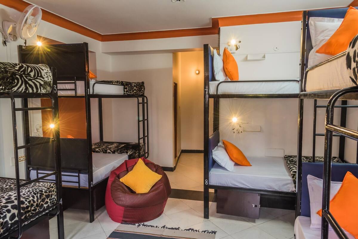Un dormitorio con literas, un sillón de peluche y un escritorio pequeño.