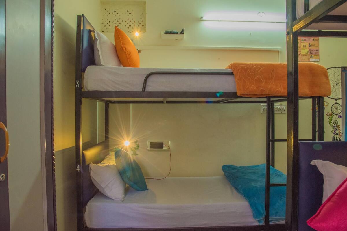 Habitación con literas, un escritorio y una pequeña estantería.