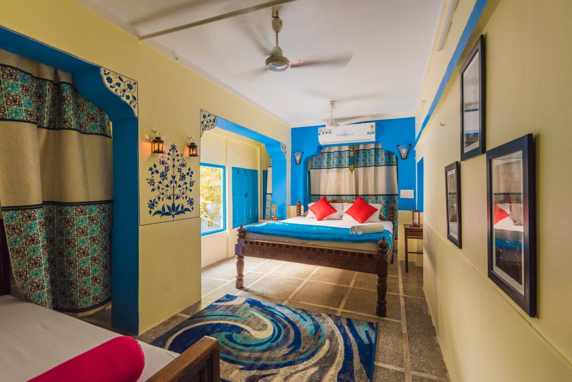 A room with a bed, a ceiling fan, and a window.