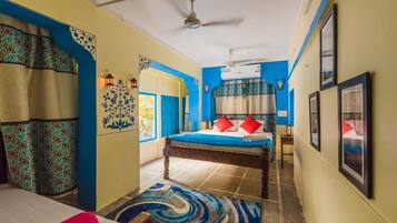 A room with a bed, a ceiling fan, and a window.