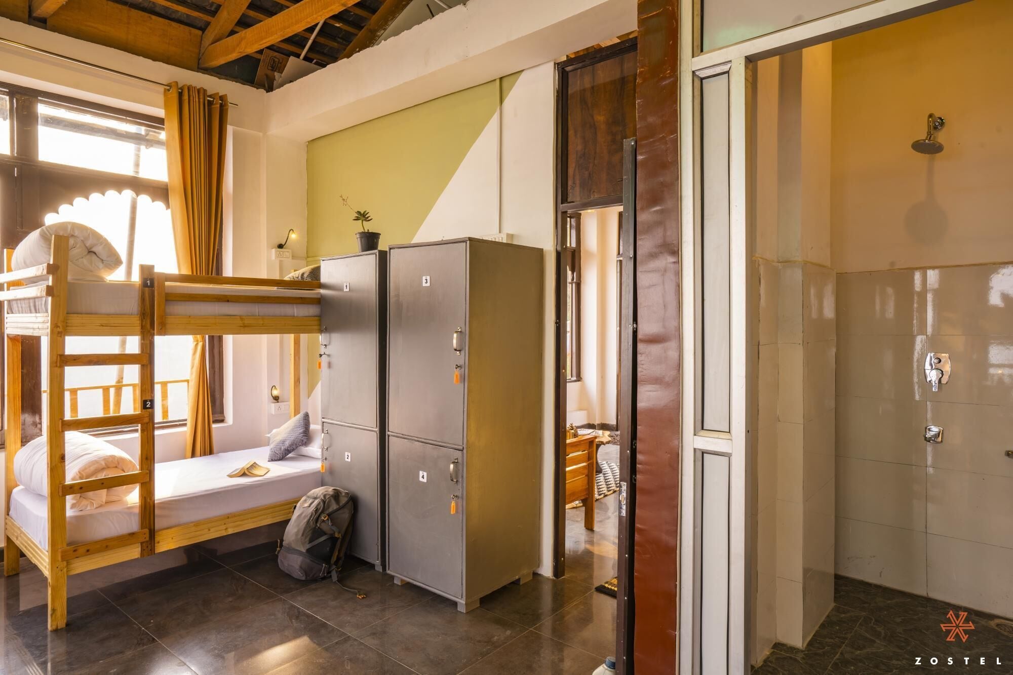 Une chambre de dortoir avec des lits superposés, une armoire et un espace douche.