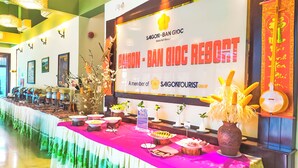 A buffet table with various dishes and a sign for Saigon - Ban Gioc Resort.