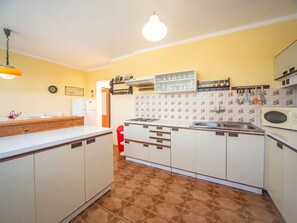 Een koelkast, een magnetron, een oven, kookgerei, borden en bestek