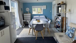 Ein gemütlicher, kleiner Wohnbereich mit Küchenzeile, Essplatz, Bett und Sitzecke.