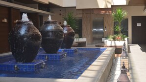 A water feature with large urns in a modern indoor setting. - Sweet Garden Guest House (Malang)