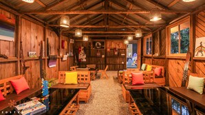 A rustic wooden interior with wooden furniture, hanging lights, and artwork on the walls. - Zostel Rinchenpong (Pelling) (Gyalshing)