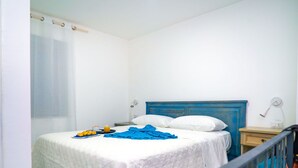 A bedroom with a bed, a bedside table, a lamp, and a window with a curtain. - Cosy apartment for 2 guests with A/C, WIFI, pool (Massa Lubrense)