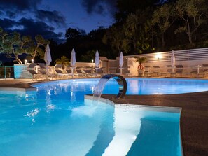 A swimming pool with a waterfall feature, surrounded by lounge chairs and umbrellas. - Lovely apartment for 2 guests with A/C, WIFI, pool (Massa Lubrense)