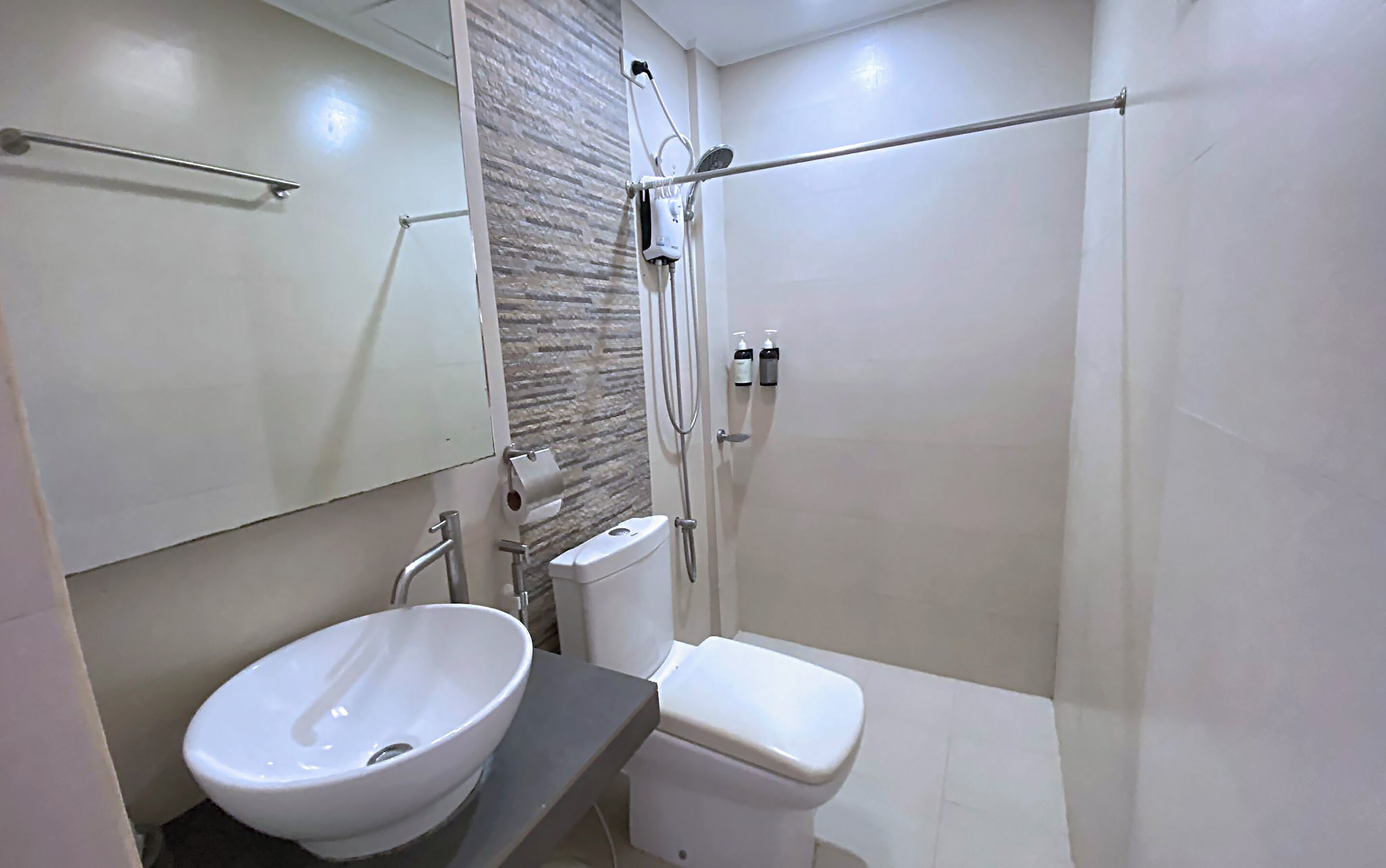 A modern bathroom with a white sink, toilet, and shower.