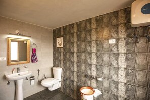 A bathroom with a sink, toilet, and shower. The walls have a patterned tile design. - Zostel Homes Cheog - Shimla (Theog)