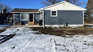A two-story house with a garage, a covered porch, and a small shed. - An escape to Sister's Haven (Pine City)