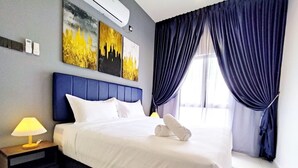 Una camera d'albergo con un grande letto, un comodino con una lampada e un'opera d'arte appesa al muro.
