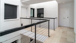 Un interior moderno con paredes blancas, un entrepiso y un piso de baldosas.
