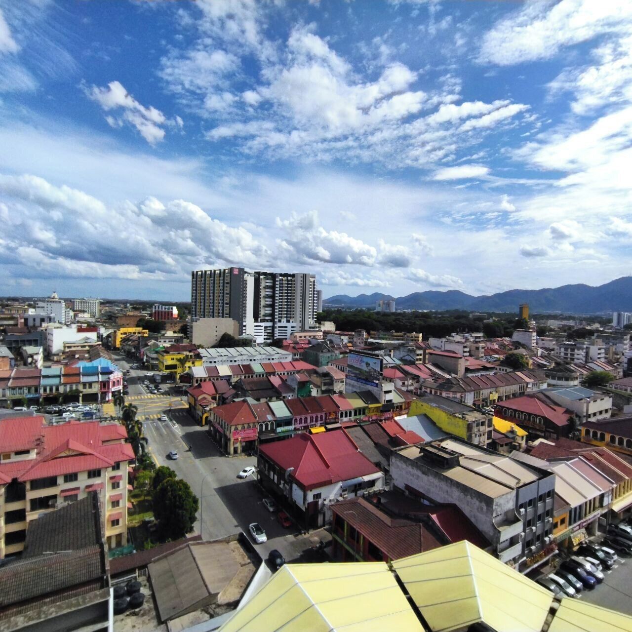 A cityscape with a variety of buildings, including a prominent high-rise and several smaller structures.