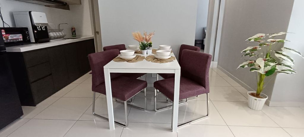 A dining area with a white table, four purple chairs, and a potted plant.