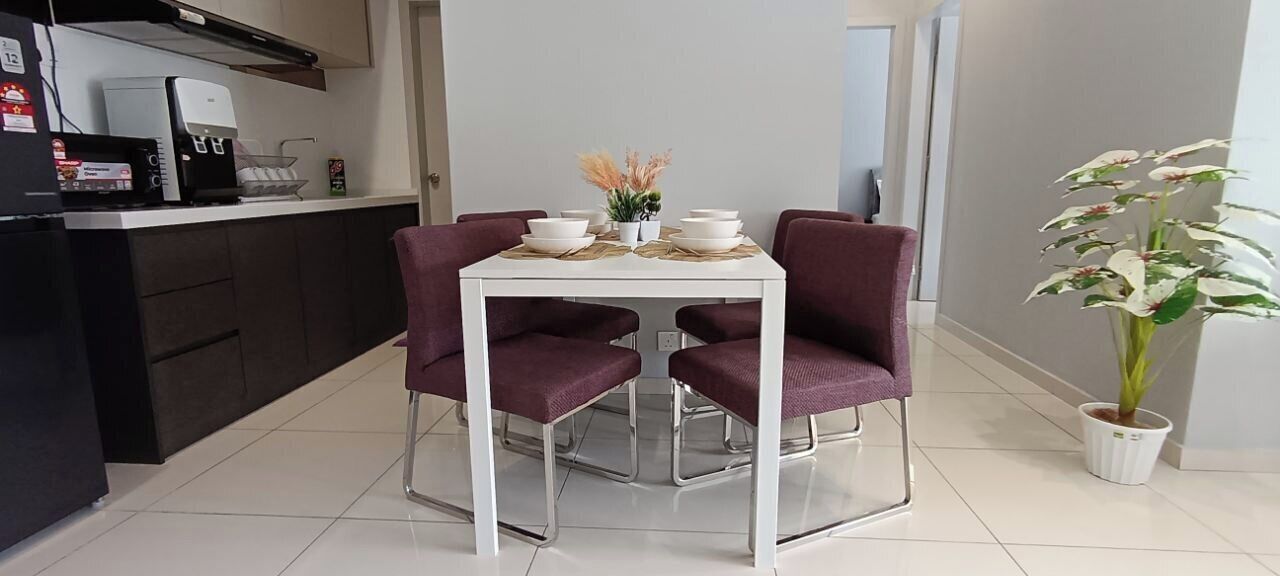 A dining area with a white table, two purple chairs, and a potted plant.